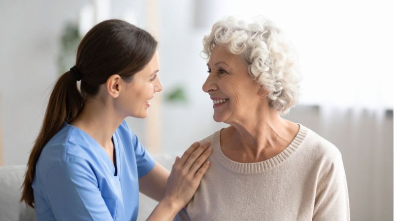 Caregiver comforting a senior woman at home.